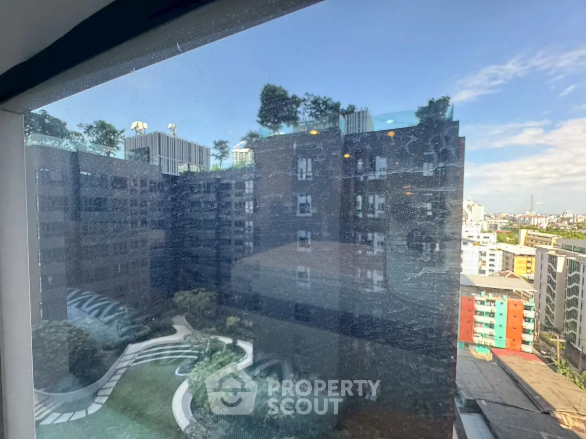 Stunning urban view from high-rise apartment window showcasing cityscape and modern architecture.