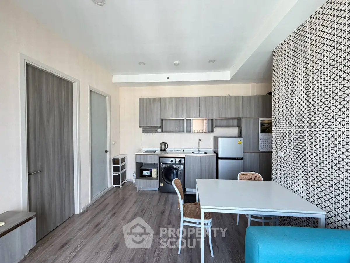 Modern kitchen with washing machine and dining area in stylish apartment