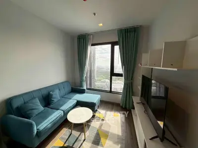 Modern living room with stylish sofa and large window offering scenic views.