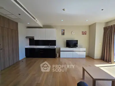 Modern open-plan living room with sleek kitchen and hardwood floors