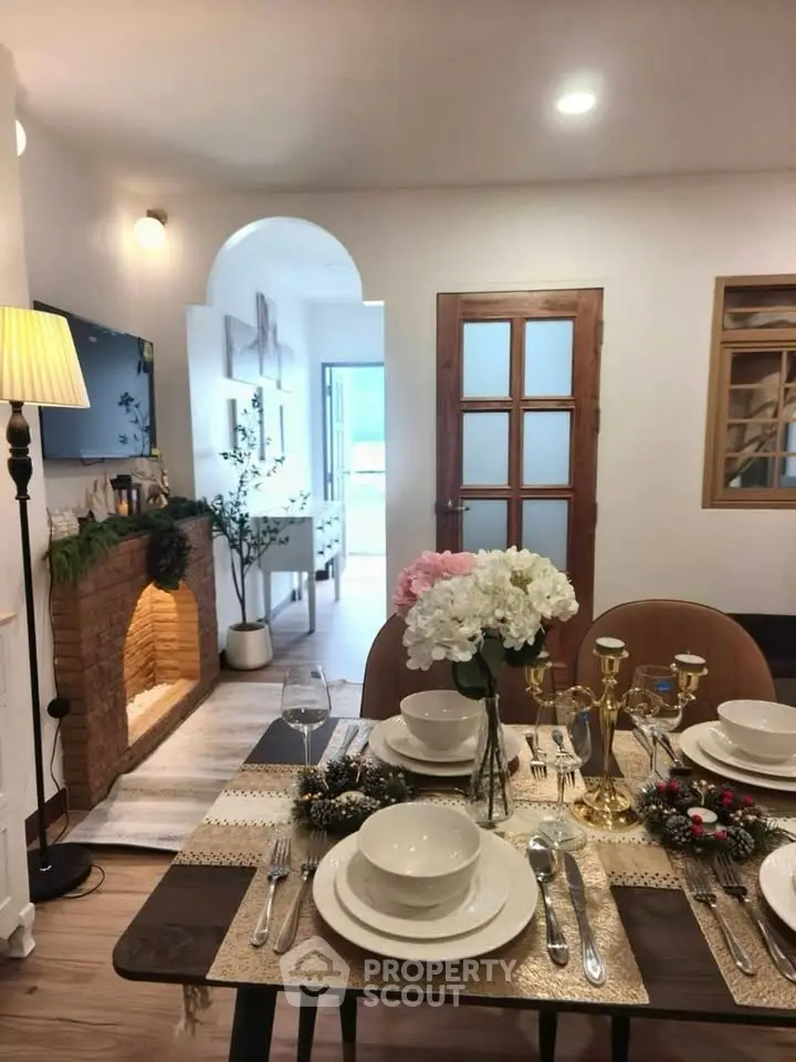 Charming living room with elegant dining setup and cozy fireplace, perfect for intimate gatherings.