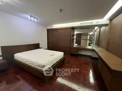 Spacious bedroom with wooden flooring and built-in wardrobe, ideal for modern living.