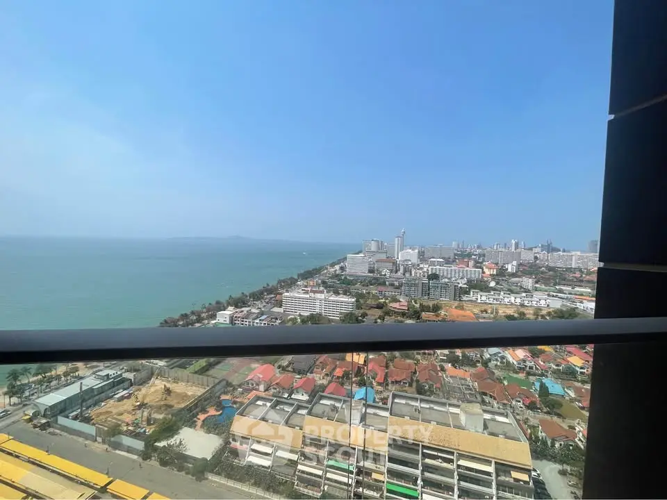Stunning ocean view from high-rise balcony overlooking cityscape and coastline.