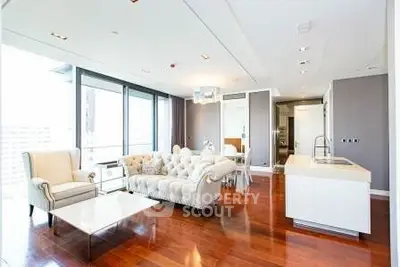Luxurious modern living room with elegant furniture and open kitchen layout in high-rise apartment.