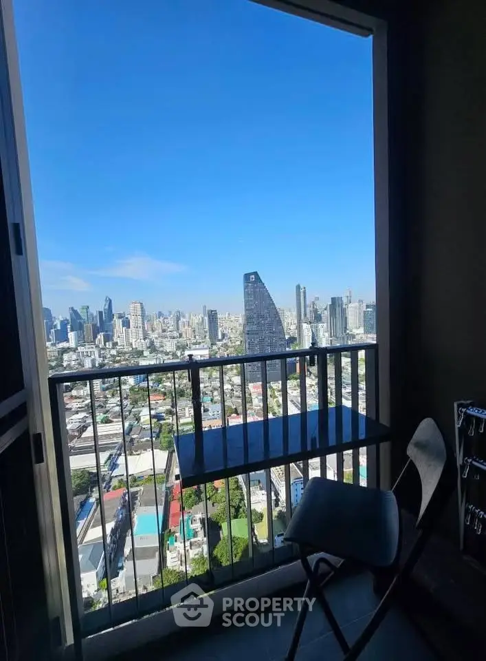 Stunning cityscape view from a high-rise balcony with modern seating, perfect for urban living.