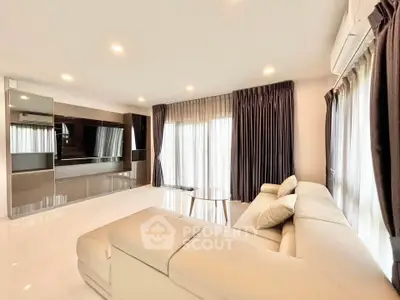 Spacious modern living room with elegant curtains and plush sofa, perfect for relaxation and entertainment.
