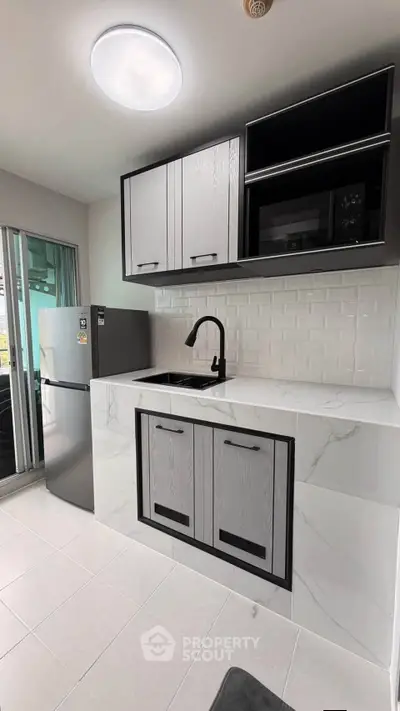 Modern kitchen with sleek cabinetry and marble countertops in a stylish apartment.