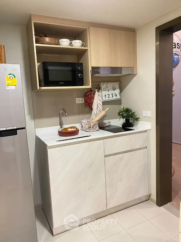 Modern compact kitchen with sleek cabinetry and built-in microwave
