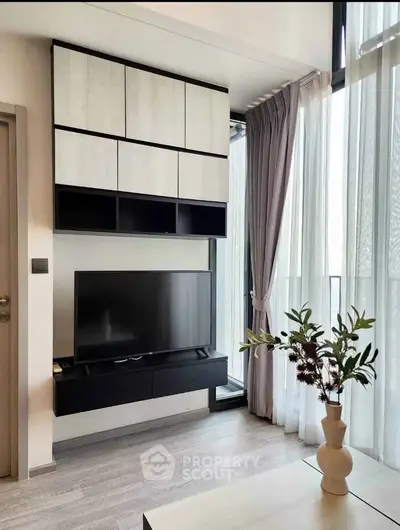 Modern living room with sleek TV setup and elegant curtains