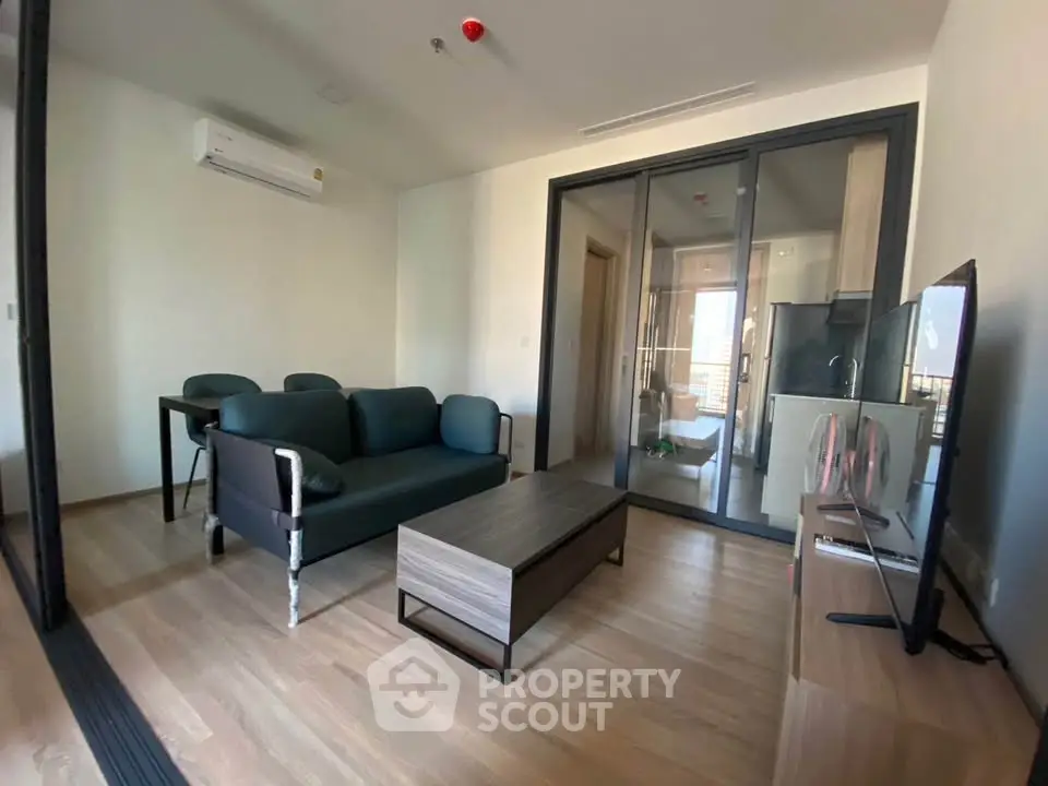 Modern living room with sleek furniture and glass partition in stylish apartment.