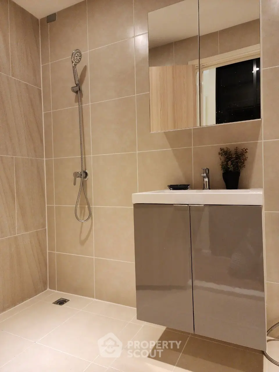 Modern bathroom with sleek vanity and walk-in shower in elegant tile design.