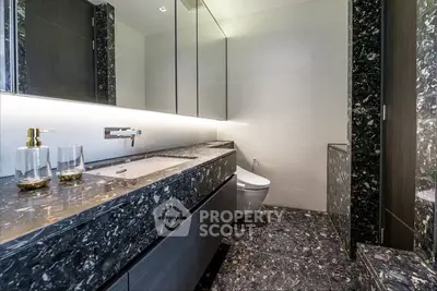 Luxurious modern bathroom with marble countertops and sleek fixtures.