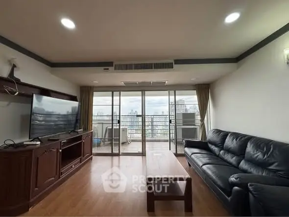 Spacious living room with leather sofa and city view balcony