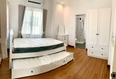 Spacious bedroom with elegant wooden flooring and ensuite bathroom