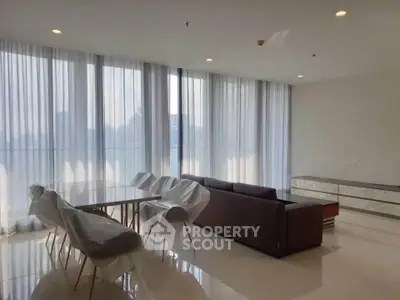 Spacious modern living room with elegant dining area and floor-to-ceiling windows.