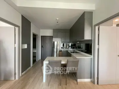 Modern kitchen with sleek cabinetry and dining area in contemporary apartment