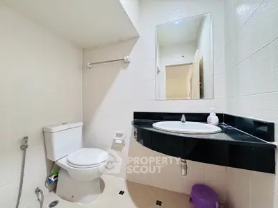 Modern bathroom with sleek fixtures and elegant black countertop.