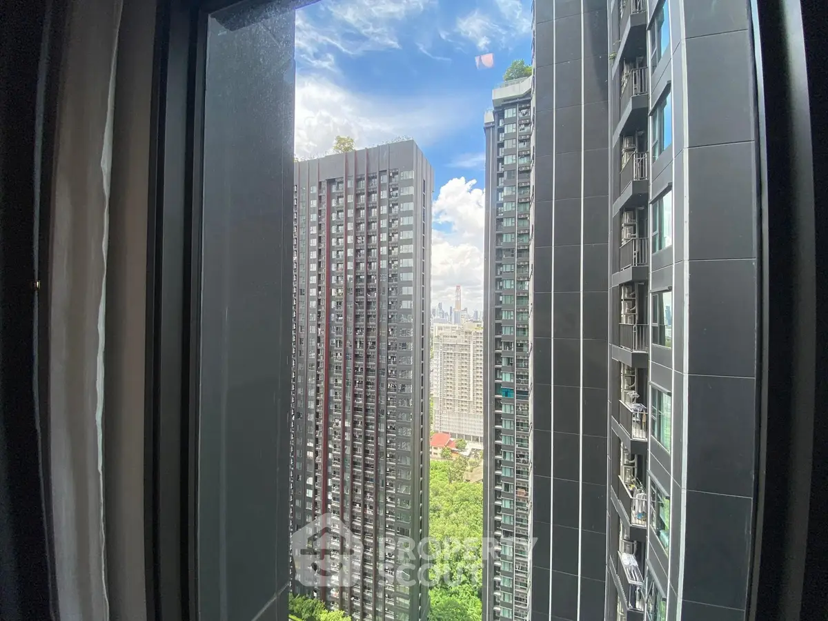 Stunning urban view from high-rise building window showcasing city skyline and modern architecture.