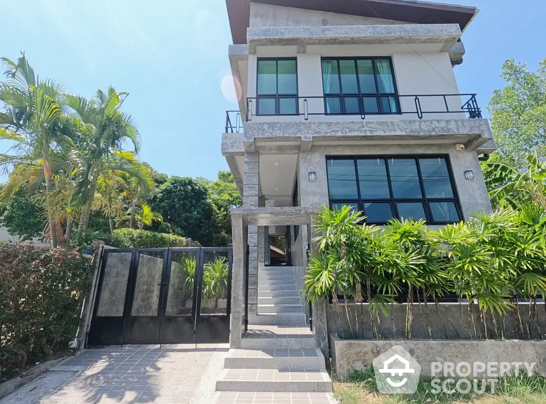 Luxurious multi-story residence with lush landscaping and a grand entrance, featuring modern architecture and expansive windows.