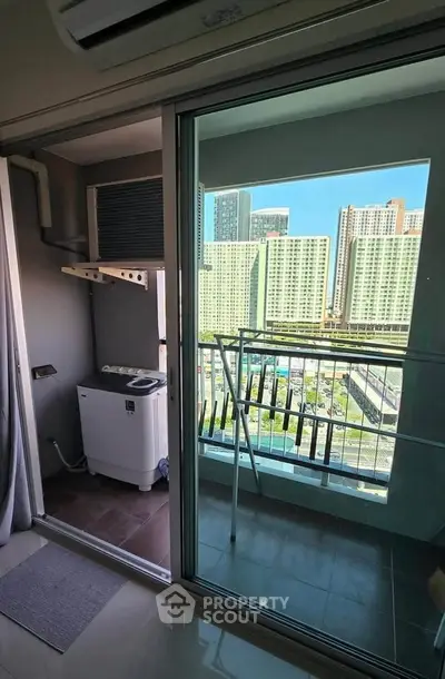 Modern apartment balcony with washing machine and city view, perfect for urban living.
