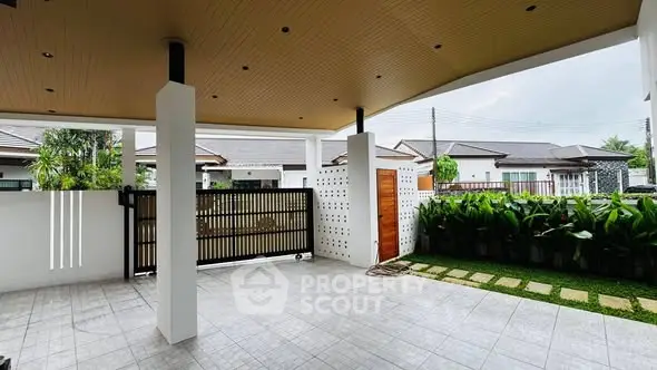 Spacious covered patio with modern design and lush garden view in a serene neighborhood.