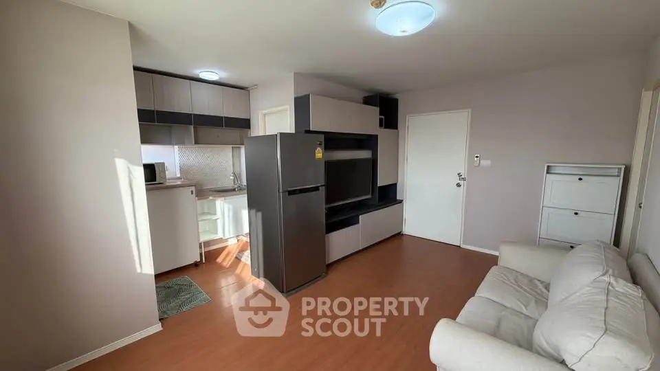 Modern apartment with open kitchen and cozy living area, featuring sleek appliances and stylish decor.
