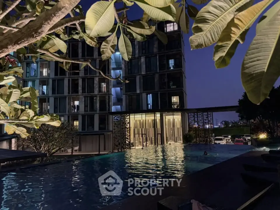 Luxurious apartment building with serene poolside view at night