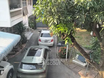 Charming residential driveway with lush garden and parked cars, perfect for family living.