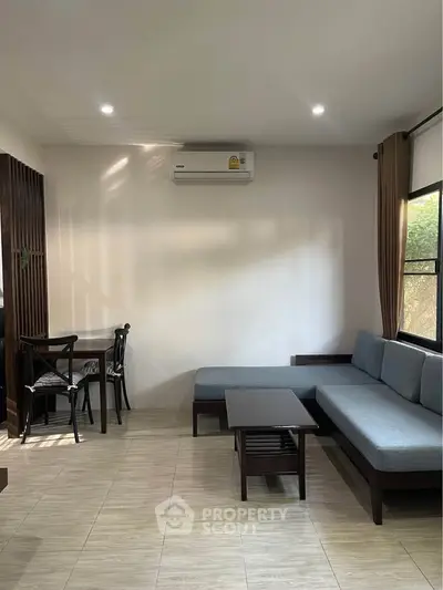 Modern living room with sleek furniture and air conditioning, perfect for relaxation.
