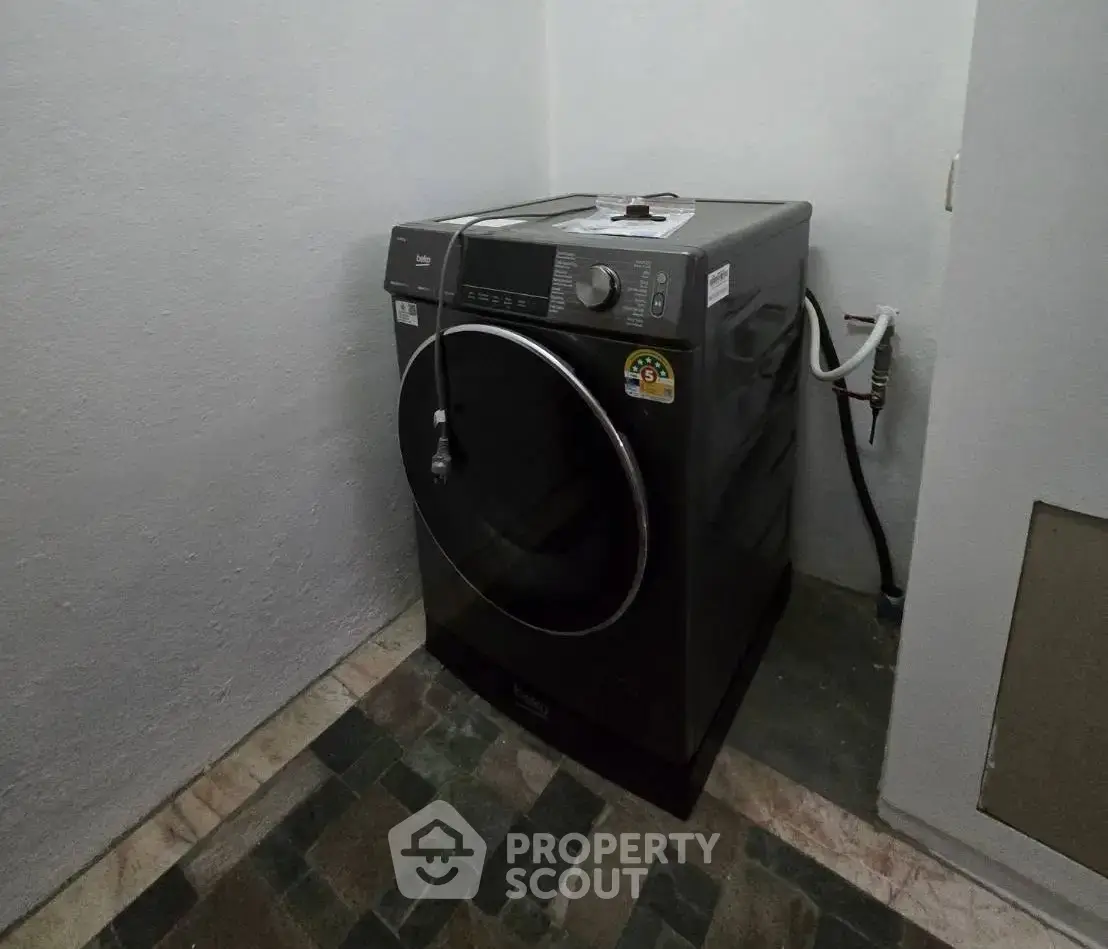 Modern washing machine in a utility room with tiled flooring, perfect for efficient laundry tasks.