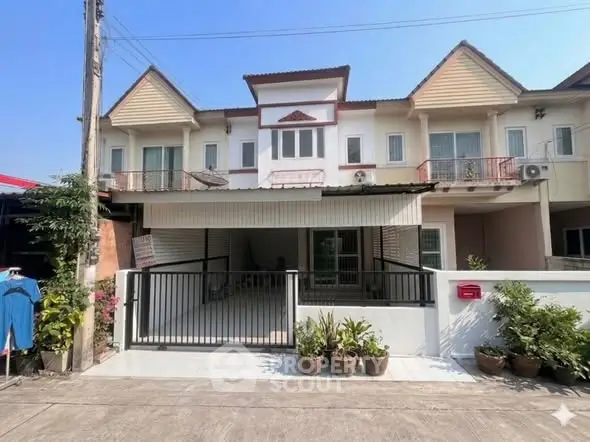 Charming townhouse with modern facade and gated entrance in a serene neighborhood.