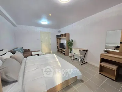 Spacious modern bedroom with cozy bed, stylish furniture, and ample natural light.