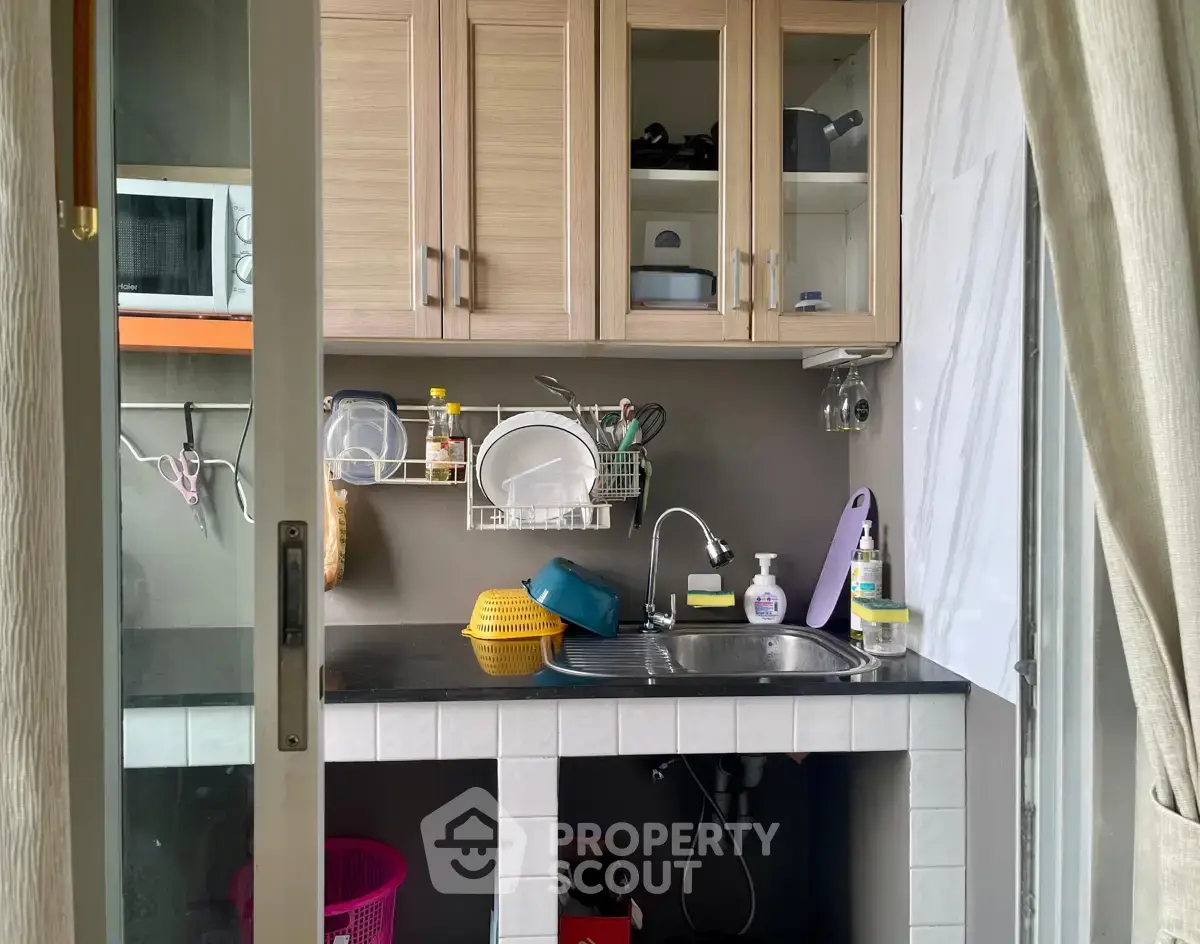 Compact kitchen with modern cabinetry and essential appliances, perfect for efficient cooking in small spaces.