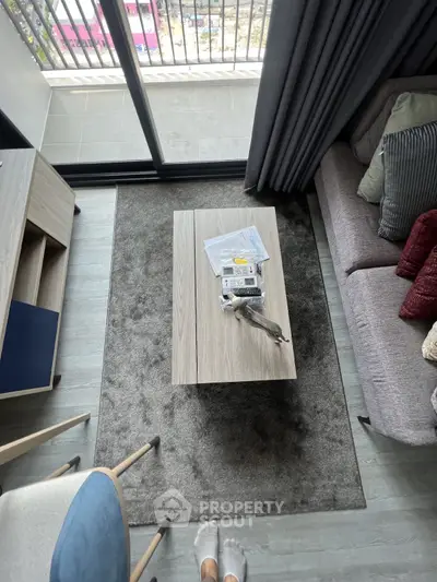 Modern living room with cozy sofa, stylish coffee table, and balcony view, perfect for urban living.