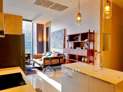 Modern open-layout kitchen and living room with stylish decor and natural light.