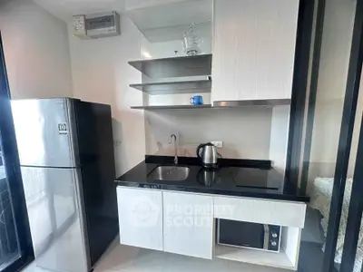 Modern kitchen with sleek cabinetry, built-in appliances, and a large fridge in a stylish apartment.