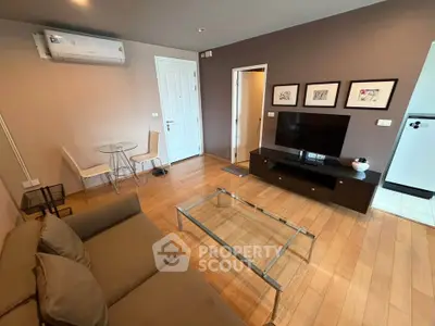 Modern living room with wooden flooring, stylish furniture, and a wall-mounted air conditioner.