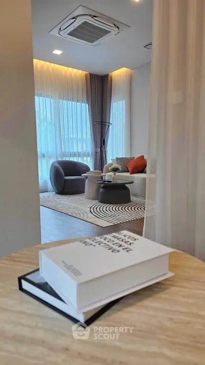Modern living room with stylish furniture and natural light, featuring a cozy seating area and elegant decor.