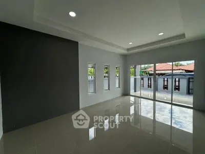 Spacious modern living room with large windows and glossy tile flooring