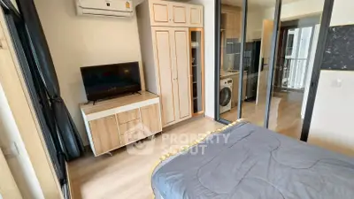 Modern bedroom with mirrored closet and in-room washing machine, featuring sleek wooden furniture and air conditioning.