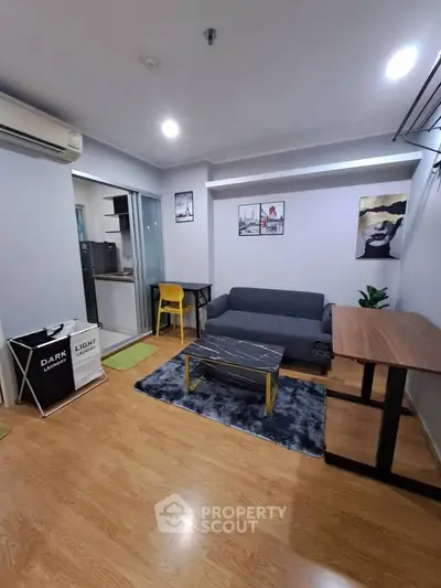 Modern living room with stylish decor and open layout, featuring a cozy sofa and sleek wooden flooring.