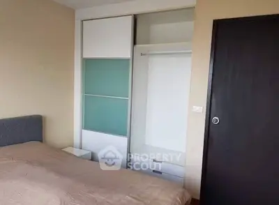 Modern bedroom with built-in wardrobe and cozy bed setup.