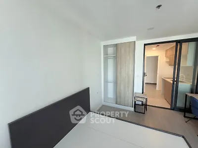 Modern bedroom with minimalist design and open view to kitchen area