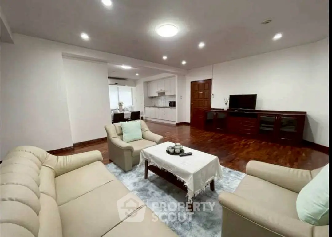 Spacious living room with elegant furniture and open kitchen layout, perfect for modern living.