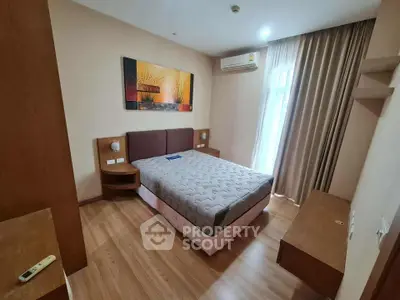 Cozy bedroom with modern decor and natural light, featuring a comfortable bed and stylish artwork.