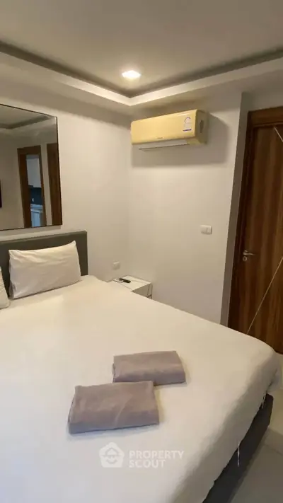 Cozy bedroom with modern air conditioning and plush bedding in a stylish apartment.