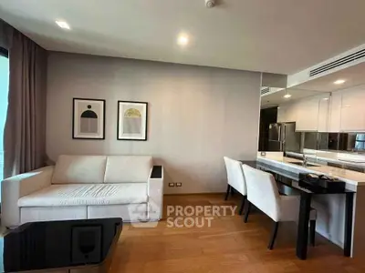 Modern living room with sleek furniture and open kitchen layout in a stylish apartment.
