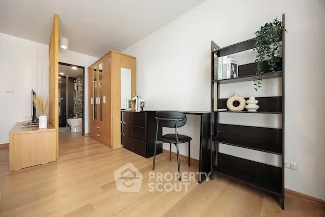 Modern study area with sleek black desk and shelving, adjacent to a stylish bathroom and wardrobe.