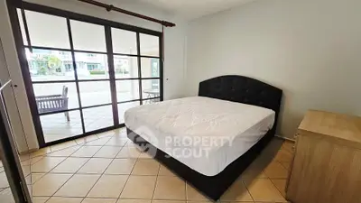 Spacious bedroom with large windows and tiled flooring in modern apartment