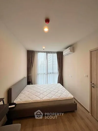 Modern bedroom with large window, air conditioning, and minimalist decor in a stylish apartment.